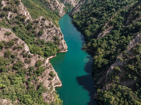 Matka Kanyonu 'nun insansız hava aracı görüntüsü. Kuzey Makedonya 'da bir gölün insansız hava aracı görüntüsü. Rocky yeşil yamaçları. Gölün şeffaf su yüzeyi. Nehir boyunca dağ yolu. Dağlarda göl