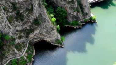 Matka Kanyonu 'nun insansız hava aracı görüntüsü. Kuzey Makedonya 'da bir gölün insansız hava aracı görüntüsü. Rocky yeşil yamaçları. Gölün şeffaf su yüzeyi. Nehir boyunca dağ yolu. Dağlarda göl