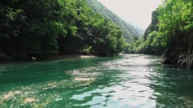 Matka Üsküp Kanyonu. Kuzey Makedonya 'daki kanyon. Treska Nehri Vadisi. Tekne gezisi. Yeşil kayalık yamaçlar. Şeffaf Matka Gölü ve turkuaz su. Kanyonun panoramik görüntüsü