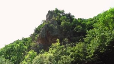 Matka Üsküp Kanyonu. Kuzey Makedonya 'daki kanyon. Treska Nehri Vadisi. Tekne gezisi. Yeşil kayalık yamaçlar. Şeffaf Matka Gölü ve turkuaz su. Kanyonun panoramik görüntüsü