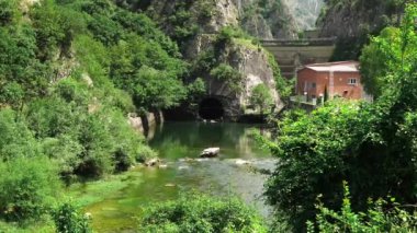 Matka Üsküp Kanyonu. Kuzey Makedonya 'daki kanyon. Treska Nehri Vadisi. Yeşil kayalık yamaçlar. Turkuaz suyu olan temiz bir göl. Matka Kanyonu 'ndaki hidroelektrik santrali. Kanyonun panoramik görüntüsü