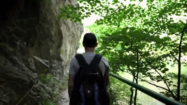 一个年轻人正沿着马特卡峡谷的一条山路走着 沿着山谷的山路 卡尼翁 马特卡 斯科普里马其顿北部的峡谷 绿色岩石斜坡 一个人在山里爬山 — 图库视频影像