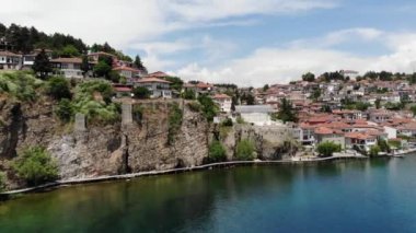 Ohri tatil beldesinin insansız hava aracı görüntüsü. Ohri Gölü 'ne ve yeşil dağların arkasına bakan küçük bir kasabaya bakan insansız hava aracı vuruldu. Ohri 'nin merkezinde tekneleri olan bir iskele, yukarıdan bir manzara..
