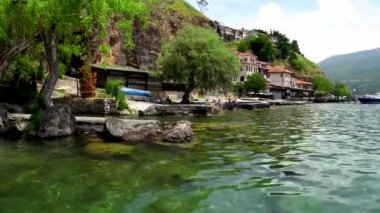 İskeleden Ohri 'ye manzara. Kuzey Makedonya 'nın Ohri kenti. Ohri Gölü 'nün doğu kıyısında bir şehir. Dağ bölgesi. Şehir seti. Kıyıya yakın tekneler. En derin ve en eski göl.