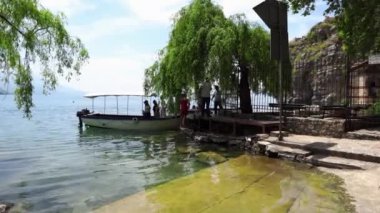 Bir grup turist Ohri Gölü 'nden bir tekneye biniyor. Tekneyle yolculuk. Gölde bir teknede dinlen. Kuzey Makedonya 'nın Ohri kenti. Ohri 'de tekne tatili