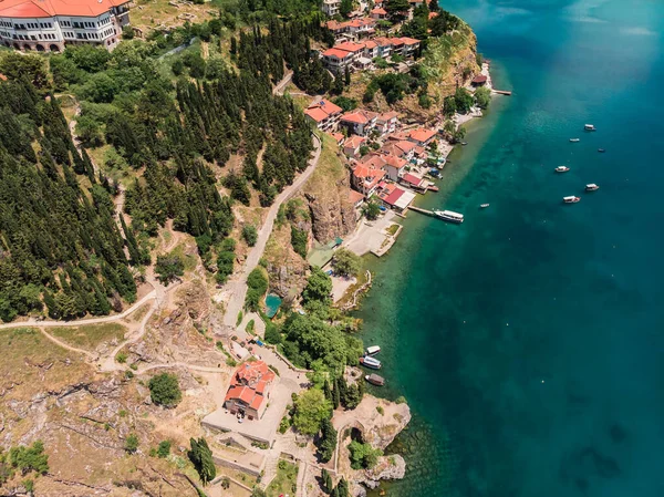 Ohri tatil beldesinin insansız hava aracı görüntüsü. Ohri Gölü 'ne ve yeşil dağların arkasına bakan küçük bir kasabaya bakan insansız hava aracı vuruldu. Ohri 'nin merkezinde tekneleri olan bir iskele, yukarıdan bir manzara..