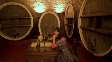 Shabo plant in the Odessa region. Wine aging in oak barrels in the cellar.  Museum in the wine cellar. A woman is photographed against the backdrop of oak barrels.
