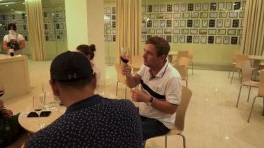 İnsanlar Shabo fabrikasında şarap tadıyorlar. Şarap Kültür Merkezi Shabo. Turistler farklı türde şaraplar denerler. İnsanlar geceyi bir kadeh şarapla geçirir.. 