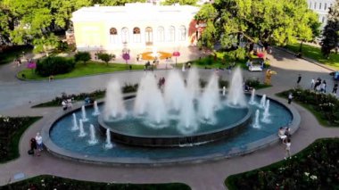 İnsansız hava aracı çekimleri Odessa Opera ve Bale Tiyatrosu 'nun çeşmesinin yanında dinleniyor. İnsanlar Odessa 'daki bir çeşmenin arka planında fotoğraflanıyor. Çiçek yatakları