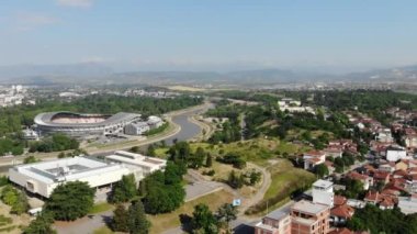 Kuzey Makedonya 'nın başkenti Üsküp' teki stadyumun panoramik insansız hava aracı görüntüsü. Üsküp Şehir Stadyumu. Kuzey Makedonya 'nın en uzun nehri Vardar' ın insansız hava aracı manzarası.