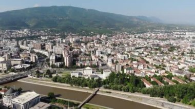 Makedonya 'nın kuzeyindeki Üsküp kentinin panoramik insansız hava aracı görüntüsü. Üsküp kentinin zeminine karşı dev dağlar. Vardar Nehri üzerindeki köprünün insansız hava aracı görüntüsü.