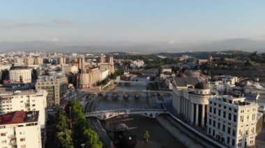 Makedonya 'nın kuzeyindeki Üsküp kentinin insansız hava aracının panoramik görüntüsü. Vardar Nehri üzerindeki köprülerin insansız hava aracı görüntüsü. Makedonya 'da bir şehrin üzerinden uçmak. Nehirdeki gemi restoranı
