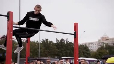 Workout sports competitions inNorthern Europe.Young athletes show acrobatic stunts on the crossbar. Street training of athletes on bars and horizontal bars. Gymnastics
