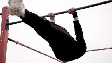 Workout sports competitions inNorthern Europe.Young athletes show acrobatic stunts on the crossbar. Street training of athletes on bars and horizontal bars. Gymnastics