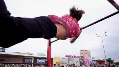 Workout sports competitions inNorthern Europe.Young athletes show acrobatic stunts on the crossbar. Street training of athletes on bars and horizontal bars. Gymnastics
