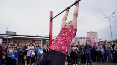Workout sports competitions inNorthern Europe.Young athletes show acrobatic stunts on the crossbar. Street training of athletes on bars and horizontal bars. Gymnastics