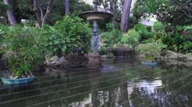 Monako şehir parkındaki çeşme. Ağaçları ve yeşil çalıları olan bir bahçe. Akdeniz kıyısındaki Doğa