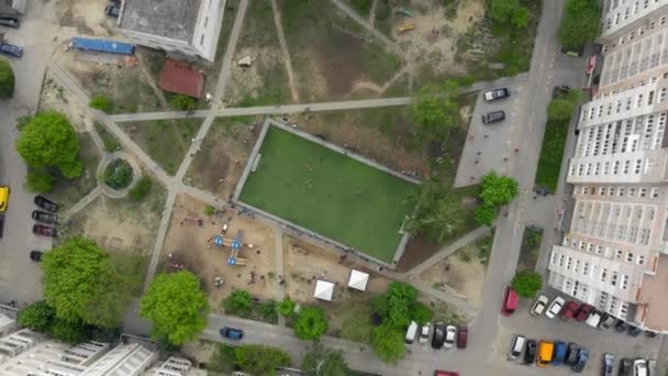 Fotbalisté hrají fotbal na fotbalovém hřišti na dvoře, pohled z dronu. Děti si hrají na fotbal. Dětský fotbalový zápas v severní Evropě. Výstřel dronů.