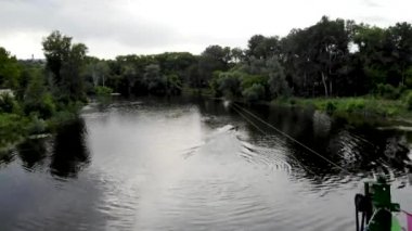 Kuzey Avrupa 'daki yeşil bir şehrin panoramik insansız hava aracı görüntüsü. Kumlu sahilleri olan bir adada insansız hava aracı vuruldu. Ukrayna 'daki Psel nehri üzerindeki yaya köprüsü, Sumy şehri. İnsanlar sahilde dinleniyor.