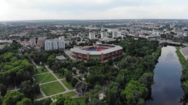 Kuzey Avrupa 'daki yeşil bir şehrin panoramik insansız hava aracı görüntüsü. Kumlu sahilleri olan bir adada insansız hava aracı vuruldu. Ukrayna 'daki Psel nehri üzerindeki yaya köprüsü, Sumy şehri. İnsanlar sahilde dinleniyor.
