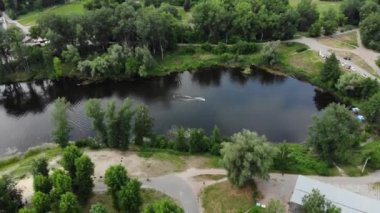 Kuzey Avrupa 'daki yeşil bir şehrin panoramik insansız hava aracı görüntüsü. Kumlu sahilleri olan bir adada insansız hava aracı vuruldu. Ukrayna 'daki Psel nehri üzerindeki yaya köprüsü, Sumy şehri. İnsanlar sahilde dinleniyor.