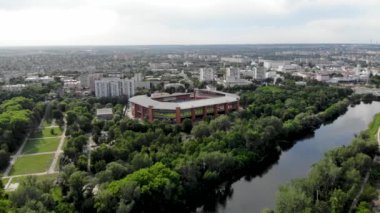 Kuzey Avrupa 'daki yeşil bir şehrin panoramik insansız hava aracı görüntüsü. Kumlu sahilleri olan bir adada insansız hava aracı vuruldu. Ukrayna 'daki Psel nehri üzerindeki yaya köprüsü, Sumy şehri. İnsanlar sahilde dinleniyor.