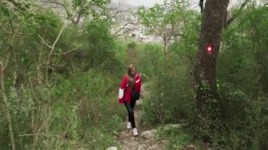 Genç bir kız Karadağ dağlarında yürüyor. Yıkılmış kaleye giden dağ yolundan yükselin. Sutomore Karadağ 'daki kale. Karadağ dağlarında dinlenin. Dağlarda yürüyüş..
