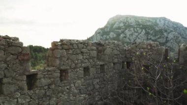Harap haldeki Hac Nejj Kalesi. Sutomore Karadağ 'daki kale. Karadağ kıyılarında Venedikliler tarafından inşa edilen ortaçağ kalesi. Dağların manzarası harika. Budva Riviera.