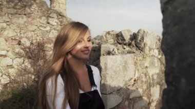 Harap olmuş Hac Nehai Kalesi 'nde bir kız yürüyor. Sutomore Karadağ' daki kale. Kız, dağların arka planında poz veriyor. Dağlarda yürüyüş. Ortaçağ Kalesi. 