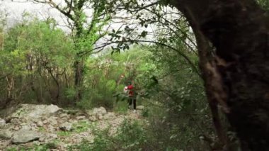 Genç bir kız Karadağ dağlarında yürüyor. Yıkılmış kaleye giden dağ yolundan yükselin. Sutomore Karadağ 'daki kale. Karadağ dağlarında dinlenin. Dağlarda yürüyüş..