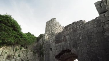 Harap haldeki Hac Nejj Kalesi. Sutomore Karadağ 'daki kale. Karadağ kıyılarında Venedikliler tarafından inşa edilen ortaçağ kalesi. Dağların manzarası harika. Budva Riviera.