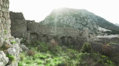 Harap haldeki Hac Nejj Kalesi. Sutomore Karadağ 'daki kale. Karadağ kıyılarında Venedikliler tarafından inşa edilen ortaçağ kalesi. Dağların manzarası harika. Budva Riviera.