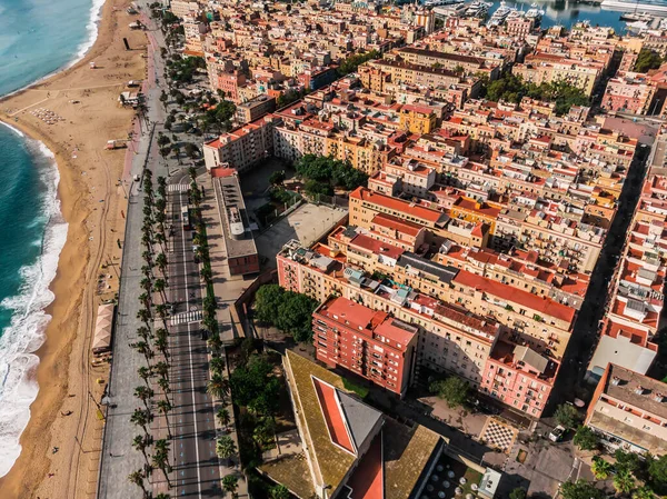 バルセロナを撃った 海岸近くのボートとポート バルセロナでの活気に満ちたスイミングと日光浴のビーチのドローンビュー 人々はビーチでリラックスしています バルセロナの街のパノラマビュー ストック画像