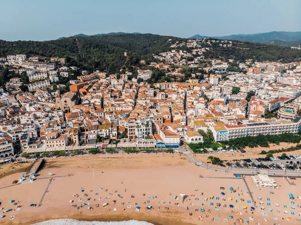 Tossa de Mar 'daki deniz manzaralı kalenin drone görüntüsü. İspanya 'da bir belediyenin insansız hava aracı çekimi. İnsanlar İspanya 'da kumlu bir plajda dinleniyor. Akdeniz yakınlarındaki bir kaplıca kasabası