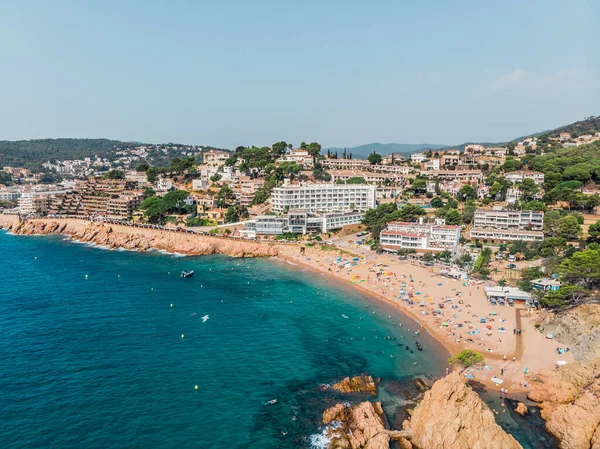 Tossa de Mar 'daki deniz manzaralı kalenin drone görüntüsü. İspanya 'da bir belediyenin insansız hava aracı çekimi. İnsanlar İspanya 'da kumlu bir plajda dinleniyor. Akdeniz yakınlarındaki bir kaplıca kasabası