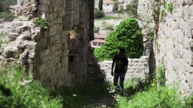 Adam Karadağ 'daki Eski Bar kalesinde yürüyor. Karadağ 'daki Stari Bar Rumia Dağı' nın eteğindeki Londsha tepesinde. Açık hava müzesi. Karadağ 'ın güneydoğusunda antik evler ve kalıntılar.