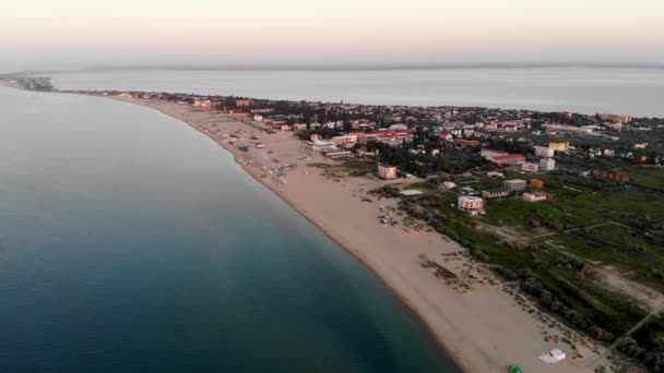 日の出の座高リゾートのドローン撮影 海の近くのビーチで日光浴の人々のドローンビュー 黒海の近くの広い砂浜 人々は海で泳ぐ 座高市にリゾート — ストック動画