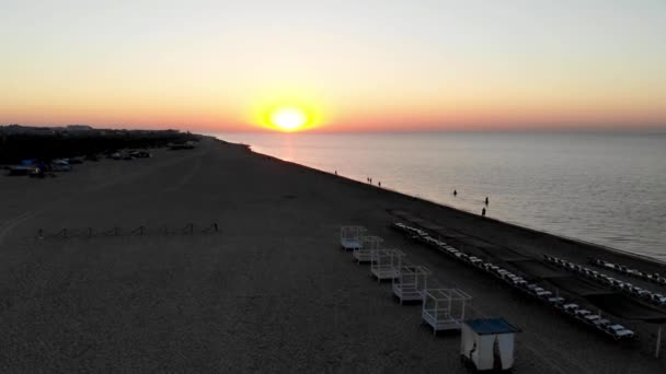 無人機は 座高の黒海で日の出を撮影しました 日の出オデッサ 人々は日の出に海を歩いている オデッサの海に太陽の最初の光線 日の出時の座高リゾートのドローン撮影 — ストック動画