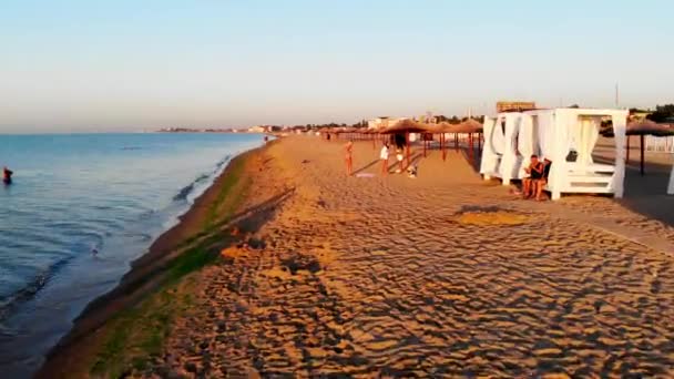 座高リゾートのドローン撮影 オデッサの海の近くのビーチで日光浴の人々のドローンビュー 黒海の近くの広い砂浜 人々は海で泳ぐ — ストック動画