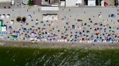 Deniz kenarındaki kumlu bir sahilde dinlenen insansız hava aracının görüntüsü. İnsanlar Odessa 'da Karadeniz' de güneşlenip yüzüyor. Yaz tatili. Denizde tatil. Temiz deniz kıyısında dinlenme. Spa tatili