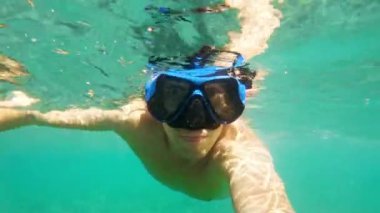 Genç bir adam İspanya 'da özel ekipmanları olmadan Akdeniz' de su altında yüzüyor. Adam suyun altına daldı. Kadavralarda serbest dalış. Nefes al-tut dalışı. Platja Grand ve Esportal plajı. 