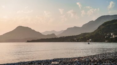 Bar Montenegro 'da dağ manzaralı gün batımı. Baraj seti. Karadağ 'daki yeşil dağlar ve deniz manzarası. Tatil köyü. Deniz kenarındaki sahilde dinleniyor. Banyo mevsimi. Tatil sezonu