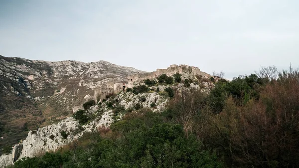 Harap haldeki Hac Nejj Kalesi. Sutomore Karadağ 'daki kale. Karadağ kıyılarında Venedikliler tarafından inşa edilen ortaçağ kalesi. Dağların manzarası harika. Budva Riviera.
