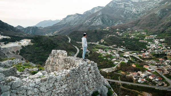 Harap olmuş Hac Nehai kalesinin kıyısında bir vadi ve dağların arkasında duran genç bir adam. Adam Karadağ 'ın dağlarının arka planında poz veriyor. Sutomore 'daki Kale