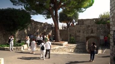 Saint-Paul-de-Vence 'in ortaçağ güçlendirilmiş köyü. Ortaçağ kareleri. Saint-Paul-de-Vence şehrinde insanlar dar bir cadde boyunca yürüyorlar. Güney Fransa