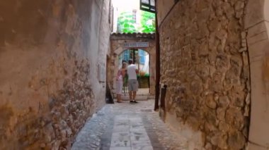 Saint-Paul-de-Vence 'in ortaçağ güçlendirilmiş köyü. Ortaçağ kareleri. Saint-Paul-de-Vence şehrinde insanlar dar bir cadde boyunca yürüyorlar. Güney Fransa