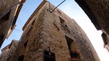 Saint-Paul-de-Vence 'in ortaçağ güçlendirilmiş köyü. İnsanlar Saint-Paul-de-Vence 'de dar bir sokakta yürüyor. Dar bir sokakta hediyelik eşya dükkanları ve galeriler 