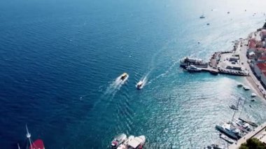 Shot from the drone, the boats blur in different directions. View from the drone to the port of the island of Brac. Drone view of an island in the Adriatic Sea in Croatia. People swim on boats