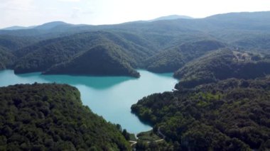 Drone Hırvatistan 'da Plitvice Lakes Ulusal Parkı' nı vurdu. Hırvatistan 'ın orta kesimindeki orman rezervi şelaleler ve kireçtaşı kanyonla birbirine bağlı bir göl. Göller arasında yürüyüş parkurları. Bir orman.