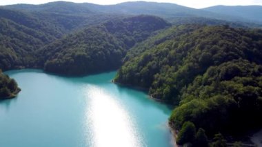 Drone Hırvatistan 'da Plitvice Lakes Ulusal Parkı' nı vurdu. Hırvatistan 'ın orta kesimindeki orman rezervi şelaleler ve kireçtaşı kanyonla birbirine bağlı bir göl. Göller arasında yürüyüş parkurları. Bir orman.